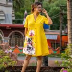 Model standing full-length in yellow hand-painted storybook cottage shirt and short set.