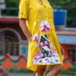Model placing hand in pocket showing practical pocket design on yellow hand-painted tunic.