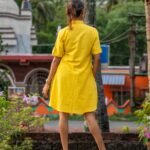 Back view of model wearing relaxed-fit yellow hand woven shirt and matching short set.