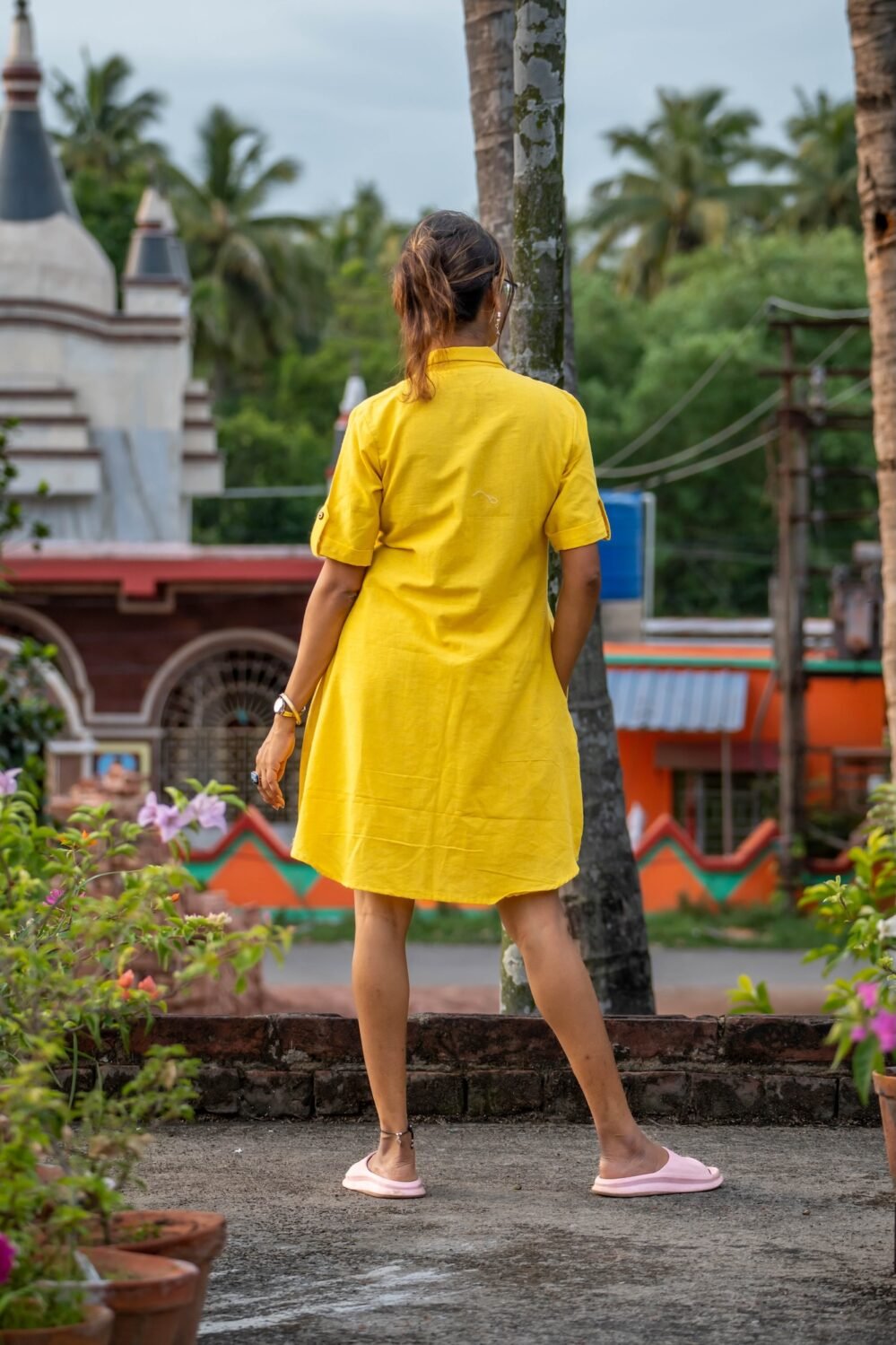 Back view of model wearing relaxed-fit yellow hand woven shirt and matching short set.