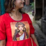 Detailed close-up of the hand-painted Maa Durga portrait on the red bodice of the gown.
