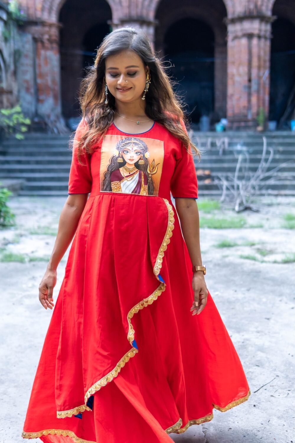 Front view of model standing in red malai cotton gown with central hand-painted Maa Durga motif.