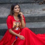 Mid-shot of model seated wearing red malai cotton gown with hand-painted Maa Durga chest artwork.